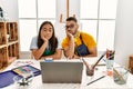 Young hispanic couple using laptop sitting on the table at art studio thinking looking tired and bored with depression problems Royalty Free Stock Photo