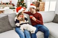 Young hispanic couple wearing christmas hat drinking coffee Royalty Free Stock Photo