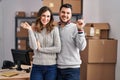 Young hispanic couple working at small business ecommerce smiling happy pointing with hand and finger to the side Royalty Free Stock Photo