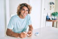 Young hispanic diabetic man smiling happy measuring glucose level at home