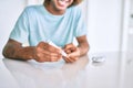 Young hispanic diabetic man smiling happy measuring glucose level at home