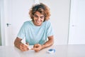 Young hispanic diabetic man smiling happy measuring glucose level at home