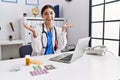 Young hispanic doctor woman wearing doctor uniform working at the clinic celebrating mad and crazy for success with arms raised Royalty Free Stock Photo