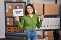 Young hispanic doctor woman working at small business ecommerce holding thank you banner smiling happy pointing with hand and Royalty Free Stock Photo