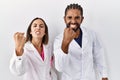 Young hispanic doctors standing over white background angry and mad raising fist frustrated and furious while shouting with anger