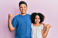Young hispanic family of brother and sister wearing casual clothes together pointing to the back behind with hand and thumbs up, Royalty Free Stock Photo
