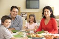 Young Hispanic Family Enjoying Meal At Home Royalty Free Stock Photo
