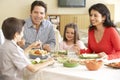 Young Hispanic Family Enjoying Meal At Home Royalty Free Stock Photo