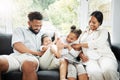 A young hispanic family happily bonding together on the sofa at home. Mixed race mother and father sitting of the couch Royalty Free Stock Photo