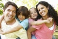 Young Hispanic Family Having Piggyback In Park Royalty Free Stock Photo