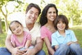 Young Hispanic Family Relaxing In Park Royalty Free Stock Photo