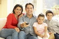 Young Hispanic Family Watching TV At Home