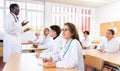 Young hispanic female medical student taking notes during group lecture Royalty Free Stock Photo