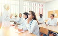 Young hispanic female medical student taking notes during group lecture Royalty Free Stock Photo