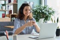 Young Hispanic female student in headphones talking online chat using laptop.