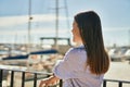 Young hispanic girl on back view leaning on the balustrad at the port