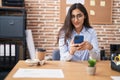 Young hispanic girl business worker using smartphone working at office Royalty Free Stock Photo