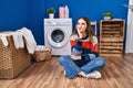 Young hispanic girl doing laundry thinking looking tired and bored with depression problems with crossed arms Royalty Free Stock Photo