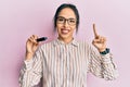 Young hispanic girl holding removable memory usb smiling with an idea or question pointing finger with happy face, number one Royalty Free Stock Photo