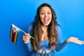 Young hispanic girl holding zimbabwe flag celebrating achievement with happy smile and winner expression with raised hand Royalty Free Stock Photo