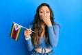 Young hispanic girl holding zimbabwe flag covering mouth with hand, shocked and afraid for mistake Royalty Free Stock Photo