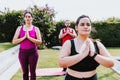 Young hispanic girl in meditation position outdoors in yoga class