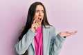 Young hispanic girl presenting with open palms, holding something angry and mad screaming frustrated and furious, shouting with