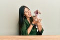 Young hispanic girl smiling happy and hugging dog sitting on the table over isolated white background Royalty Free Stock Photo