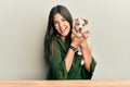 Young hispanic girl smiling happy and hugging dog sitting on the table over isolated white background Royalty Free Stock Photo