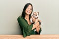 Young hispanic girl smiling happy and hugging dog sitting on the table over isolated white background Royalty Free Stock Photo