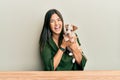 Young hispanic girl smiling happy and hugging dog sitting on the table over isolated white background Royalty Free Stock Photo