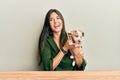 Young hispanic girl smiling happy and hugging dog sitting on the table over isolated white background Royalty Free Stock Photo