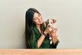 Young hispanic girl smiling happy and hugging dog sitting on the table over isolated white background Royalty Free Stock Photo