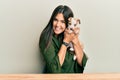 Young hispanic girl smiling happy and hugging dog sitting on the table over isolated white background Royalty Free Stock Photo