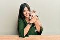 Young hispanic girl smiling happy and hugging dog sitting on the table over isolated white background Royalty Free Stock Photo