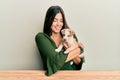 Young hispanic girl smiling happy and hugging dog sitting on the table over isolated white background Royalty Free Stock Photo