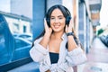 Young hispanic girl smiling happy listening to music using headphones at the city Royalty Free Stock Photo