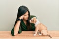 Young hispanic girl smiling happy and playing with dog sitting on the table over isolated white background Royalty Free Stock Photo