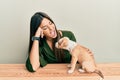 Young hispanic girl smiling happy and playing with dog sitting on the table over isolated white background Royalty Free Stock Photo