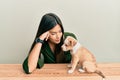 Young hispanic girl smiling happy and playing with dog sitting on the table over isolated white background Royalty Free Stock Photo