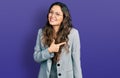 Young hispanic girl wearing business clothes and glasses cheerful with a smile of face pointing with hand and finger up to the Royalty Free Stock Photo