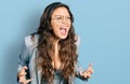 Young hispanic girl wearing business clothes and glasses crazy and mad shouting and yelling with aggressive expression and arms Royalty Free Stock Photo