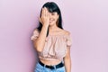 Young hispanic girl wearing casual clothes covering one eye with hand, confident smile on face and surprise emotion Royalty Free Stock Photo