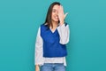 Young hispanic girl wearing casual clothes covering one eye with hand, confident smile on face and surprise emotion Royalty Free Stock Photo