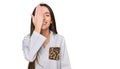 Young hispanic girl wearing casual clothes covering one eye with hand, confident smile on face and surprise emotion Royalty Free Stock Photo