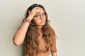 Young hispanic girl wearing casual clothes and glasses worried and stressed about a problem with hand on forehead, nervous and Royalty Free Stock Photo
