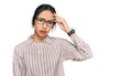 Young hispanic girl wearing casual clothes and glasses worried and stressed about a problem with hand on forehead, nervous and Royalty Free Stock Photo