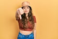 Young hispanic girl wearing casual clothes and hat looking unhappy and angry showing rejection and negative with thumbs down Royalty Free Stock Photo