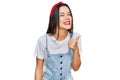 Young hispanic girl wearing casual clothes smiling with happy face looking and pointing to the side with thumb up Royalty Free Stock Photo