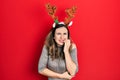 Young hispanic girl wearing deer christmas hat looking stressed and nervous with hands on mouth biting nails Royalty Free Stock Photo